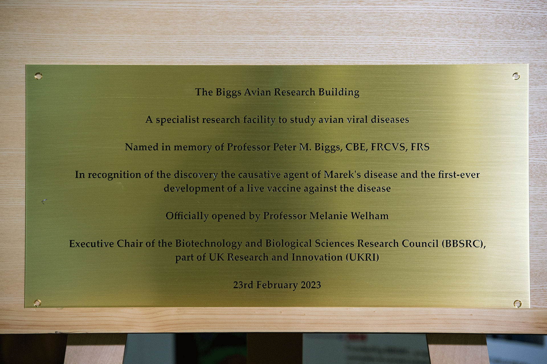 Brass plaque with black text to recognise the work of Professor Peter Biggs and who opened the building 